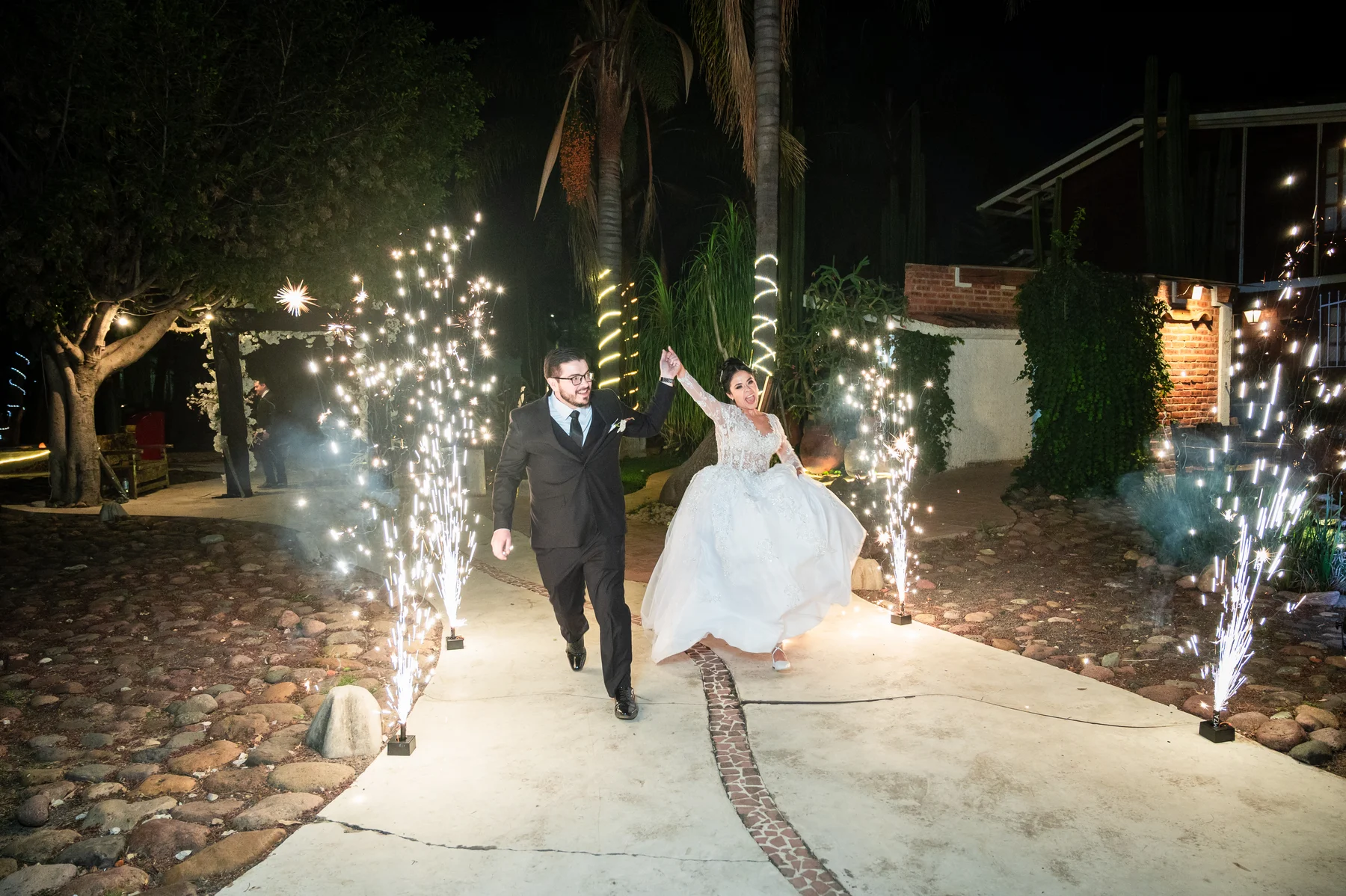 Los novios entran de la mano a la recepción entre luces de bengala
